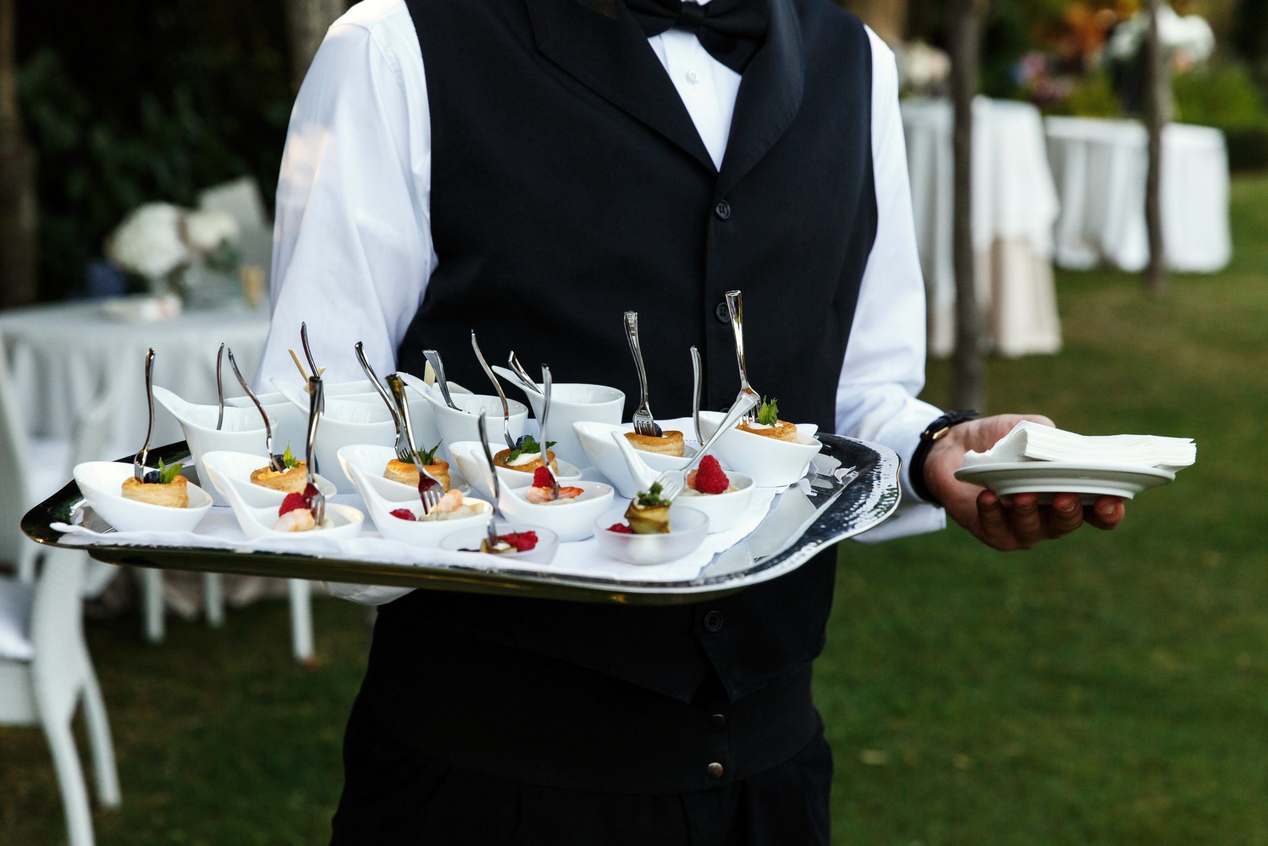 Waiter carries plate with tasty snacks